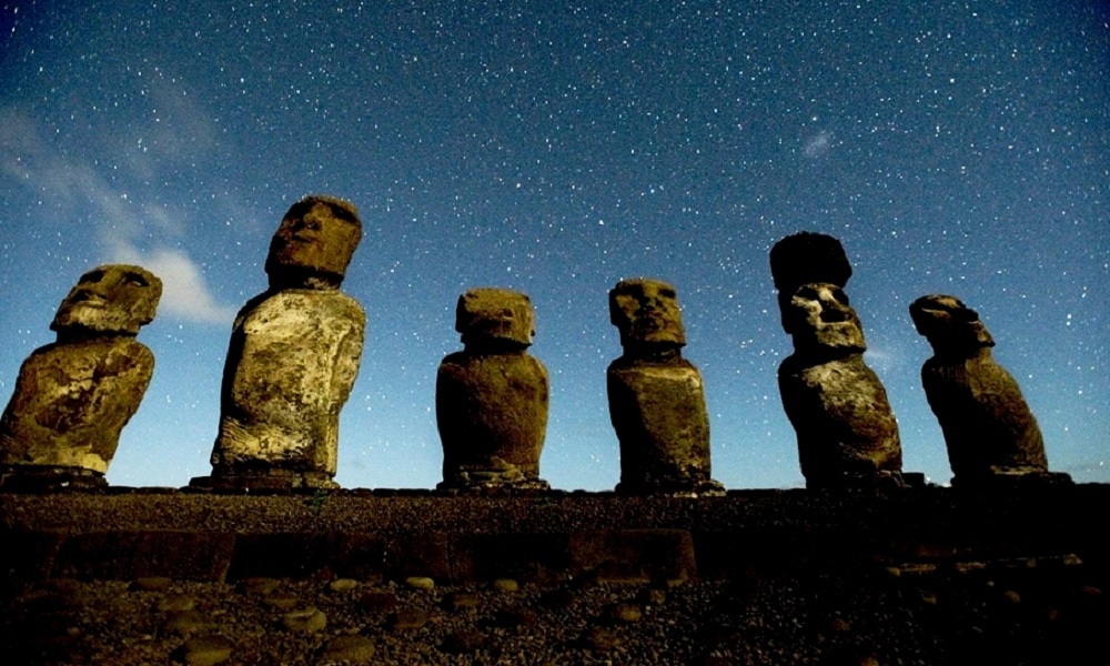 6 Moai statues with a starry night sky behind