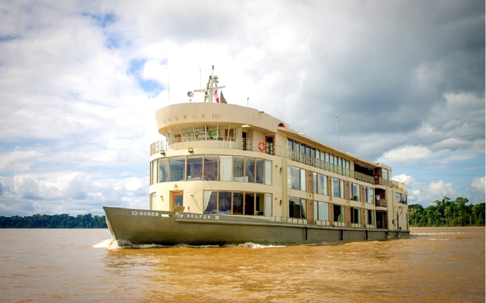 3 floor Amazon River Cruise boat on brown muddy river