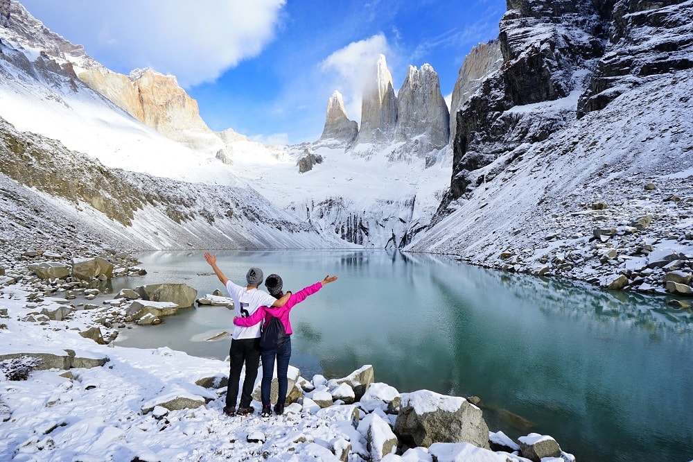 a couple of trekkers stood at lagoon over looking torres del paine